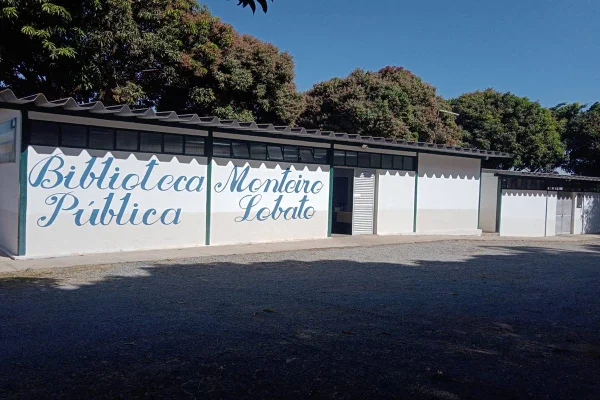 Foto de um prédio branco com árvores ao fundo