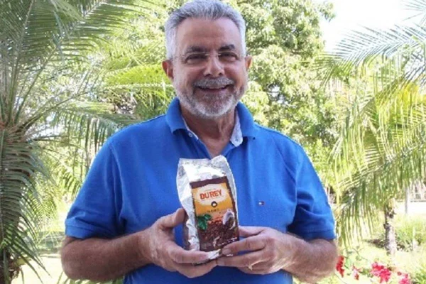 Foto colorida de um homem segurando um pacote de café-Metrópoles