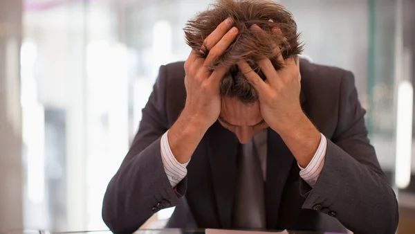 Frustrated businessman sittsinais de que o corpo está no limite