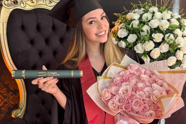 Foto colorida de Melody e uma amiga durante formatura na escola - Metrópoles