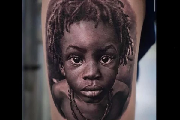 Tatuagem reproduz foto de criança negra sem autorização da família | Metrópoles