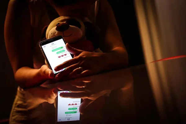 imagem colorida de mulher com celular na mão - Metrópoles
