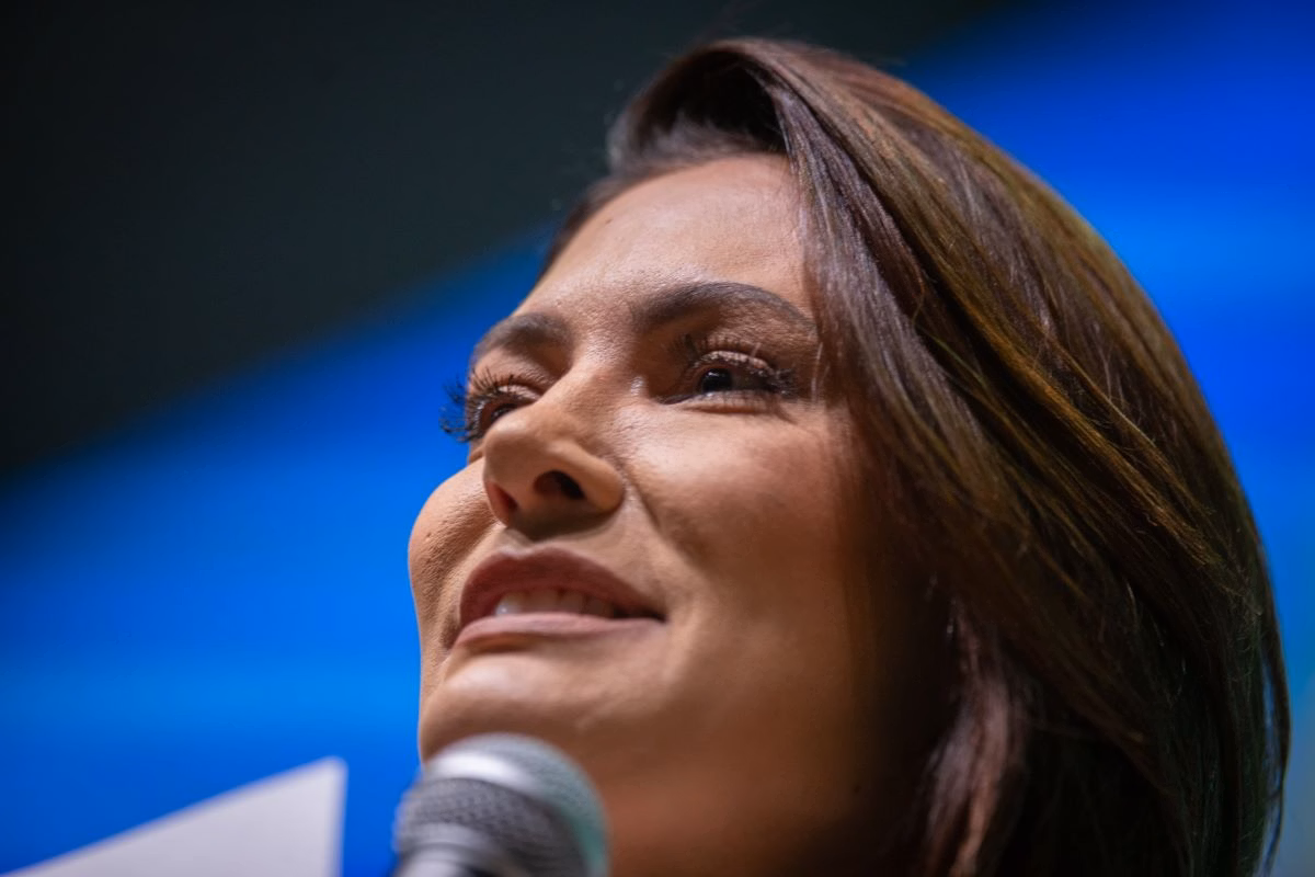 Michelle Bolsonaro com microfone durante palestra na sede de seu partido político