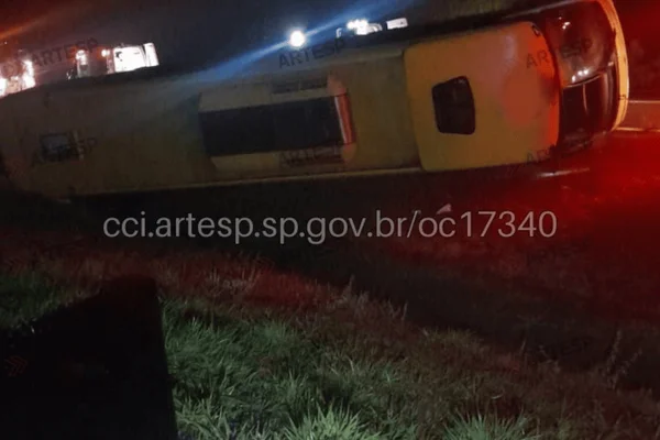 Imagem colorida de um ônibus tombado em rodovia de SP - Metrópoles