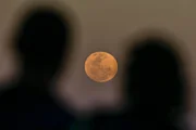 Apesar do nome, a Lua de morango não fica rosa. A coloração alaranjada registrada nas imagens é um efeito natural da atmosfera terrestre quando o satélite está próximo ao horizonte