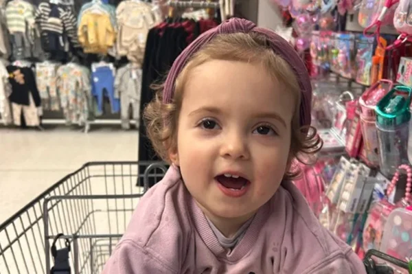 Imagem mostra bebê sorrindo enquanto está sentada em carrinho de mercado - Metrópoles