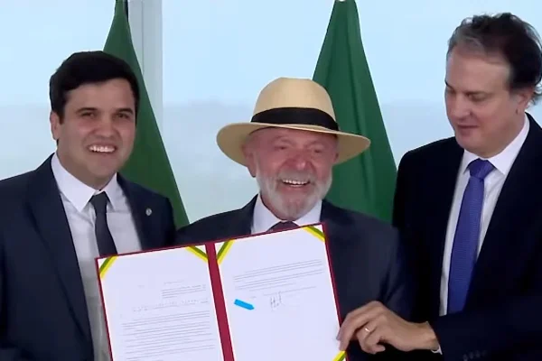 Imagem colorida de presidente Lula com texto sancionado, ao lado do deputado Ferreirinha e ministro Camilo Santana - Metrópoles