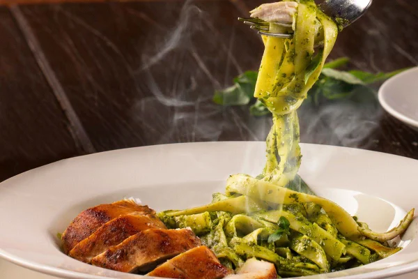 Prato de talharim ao pesto com carne enrolado em garfo - Metrópoles