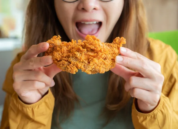 Foto colorida de mulher comendo com as mãos - Metrópoles