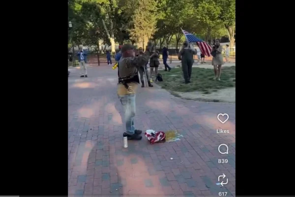 Homem ateia fogo em uma bandeira americana após ordem executiva de Donald Trump