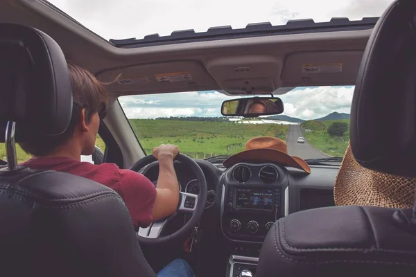 Foto colorida de homem dirigindo um carro