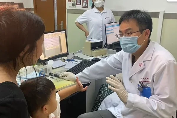 Foto colorida de mulher e criança de frente para médico - Metrópoles
