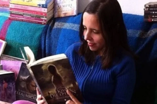 Imagem colorida de mulher lendo livro. Metrópoles