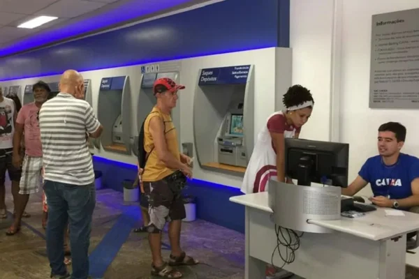 pessoas fazem fila dentro de uma agência da Caixa