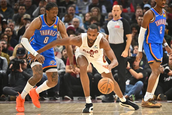 Imagem colorida de Evan Mobley tentando passar por Jalen William - Metrópoles