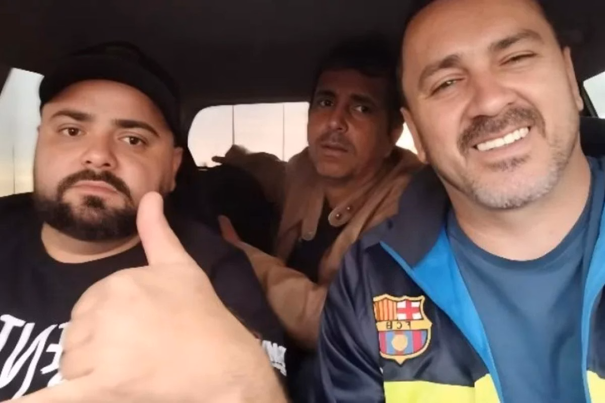 imagem colorida mostra três homens dentro de carro