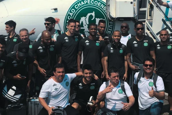 Foto de vários jogadores de futebol perfilados na frente de um avião - Metrópoles