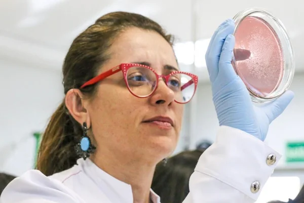 Pesquisadora analisando amostra em laboratório