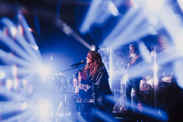 Fotografia colorida mostrando cantora cantando em palco cheio de luzes-Metrópoles