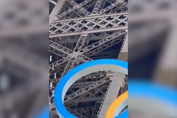 Imagem colorida de homem na Torre Eiffel - Metrópoles