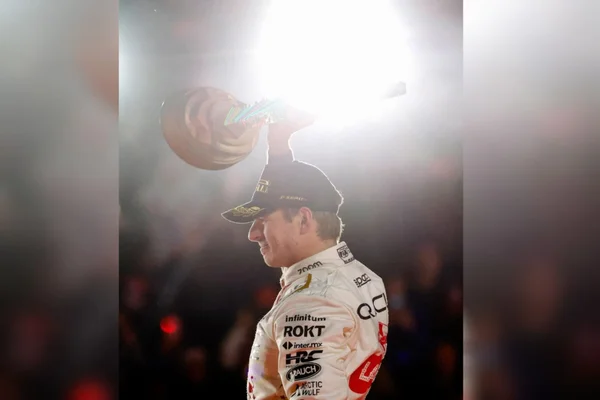 Foto mostra o Piloto Max Verstappen levantando um troféu em Las Vegas