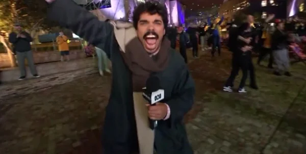 Imagem colorida de repórter comemorando a classificação da Austrália para a Copa do Mundo