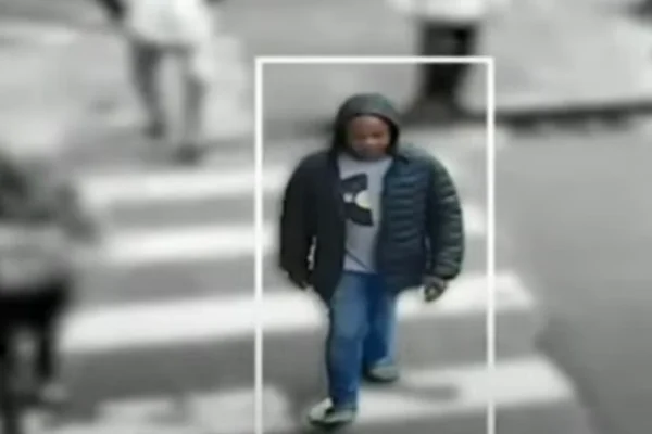 Imagem colorida de homem de blusa atravessando rua. Metrópoles