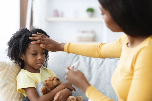 Imagem colorida de mãe medindo a febre da filha