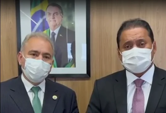 O senador Weverton em vídeo gravado ao lado do ministro da Saúde, Marcelo Queiroga, com um quadro de Jair Bolsonaro ao fundo