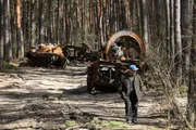 Homem passa perto de máquinas militares russas destruídas na floresta no norte de Kiev, Ucrânia Homem passa perto de máquinas militares russas destruídas na floresta no norte de Kiev, Ucrânia