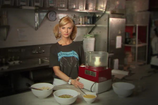 Na foto temos uma mulher dentro da cozinha de um restaurante com varias tigelas ao redor dela