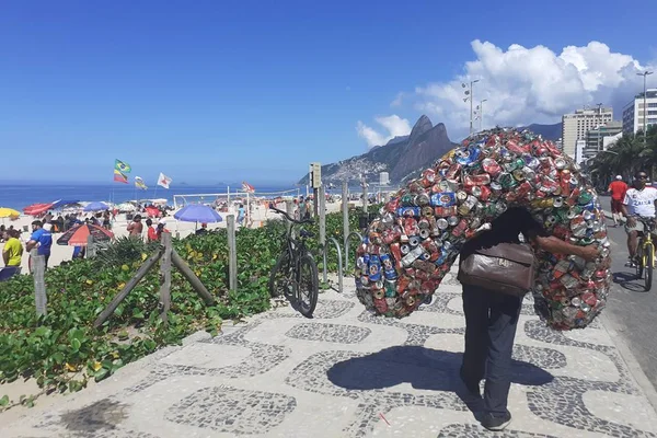 Praia do Rio de Janeiro ao fundo e catador de latinhas