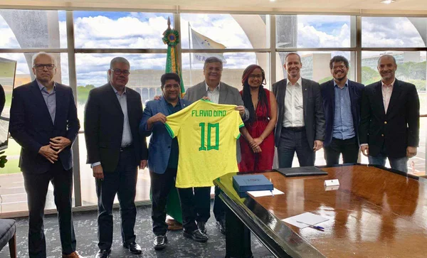 Imagem colorida mostra Flávio Dino, minsitro da Justiça, segurando uma camisa do Brasil com seu nome e o número 10. Ele está ao lado do presidente da CBF, Ednaldo Rodrigues