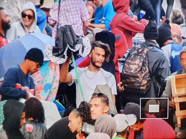 Foto colorida mostra homem em meio à multidão na Cracolândia.