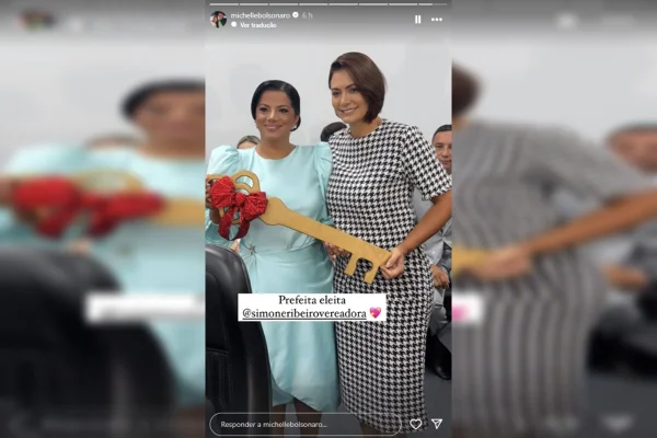 Foto de Simone Ribeiro e Michelle Bolsonaro segurando a chave da cidade