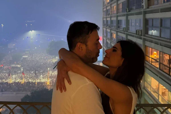 Foto colorida de André Rizek e Andréia Sadi abraçados durante pedido de casamento - Metrópoles