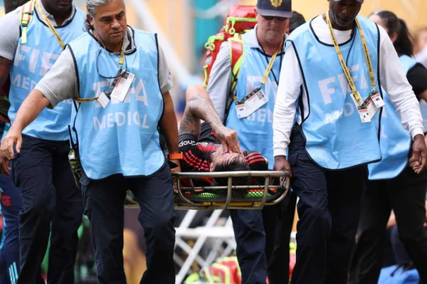 Imagem colorida de Erick Pulgar deixando o gramado de maca - Metrópoles