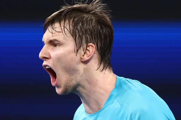 Alexander Bublik gritando em um fundo azul