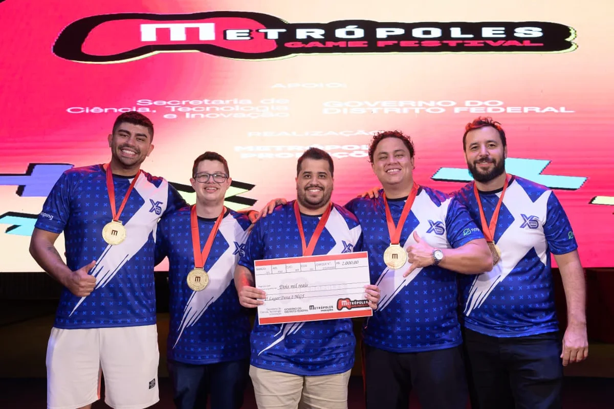 Premiação da competição de Dota 2 no Metrópoles Game Festival. A equipe X5 Gaming Academy, campeã, foi formada por Marcus, Matheus, Caio Henrique (capitão), João e Mateus Zatarah Premiação da competição de Dota 2 no Metrópoles Game Festival. A equipe X5 Gaming Academy, campeã, foi formada por Marcus, Matheus, Caio Henrique (capitão), João e Mateus Zatarah