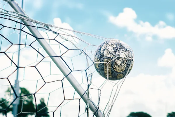 Bola de futebol na rede do gol