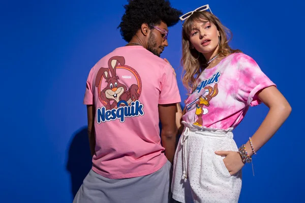 Mulher branca e homem negro com camisetas rosa