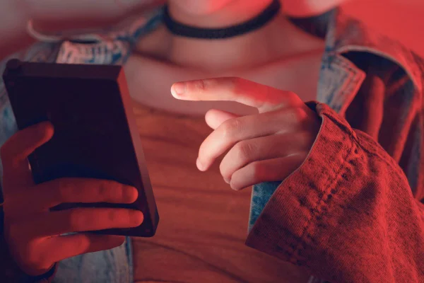 Foto colorida de adolescente mexendo no celular. Imagem ilustrativa - Metrópoles