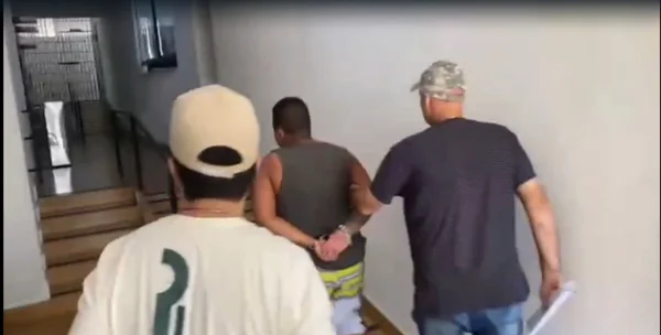 Foto colorida de vídeo de policiais civis que prenderam integrante do PCC suspeito de atacar homem a golpes de machado, em Taubaté, interior de São Paulo.