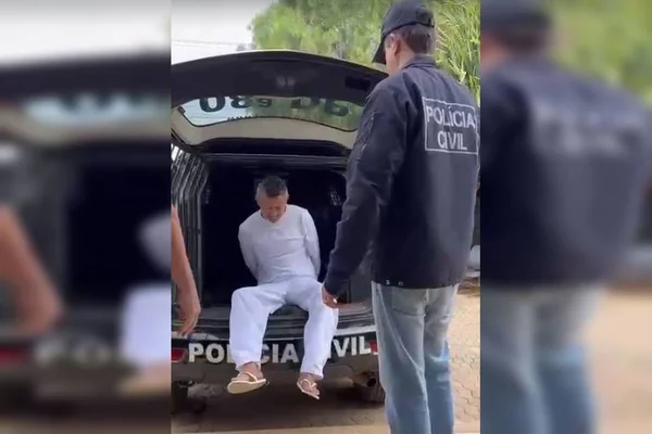 Homem vestido de branco preso em viatura