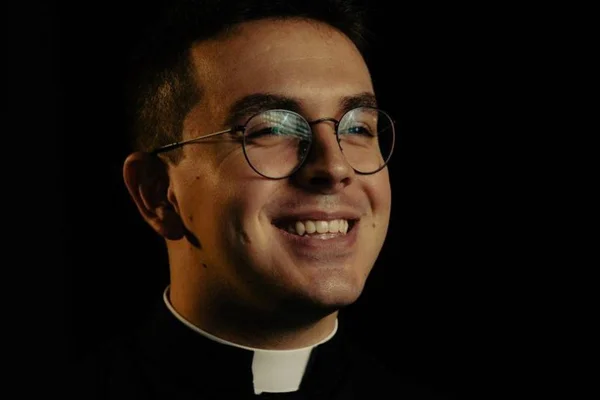 Padre Mateus Aquino, que afirmou em seu Instagram que "votar em Lula é pecado mortal". Na foto ele olha para frente, sorrindo, usa óculos redondos e batina - Metrópoles