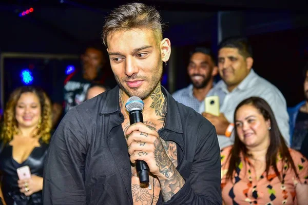 Lucas Lucco com a blusa aberta