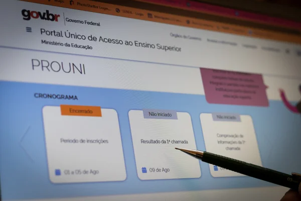 estudante aponta para tela do computador com site do Prouni