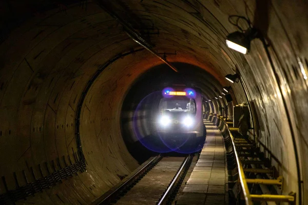 Imagem colorida mostra um trem do Metrô andando em um túnel escuro - Metrópoles