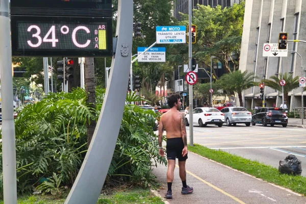 Imagem colorida mostra homem andando sem camisa pela Faria Lima em dia de calor em São Paulo - Metrópoles