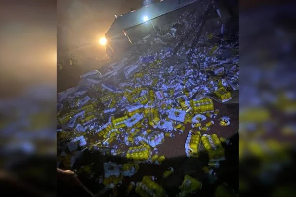 Imagem colorida mostra carga de cerveja que caiu de caminhão que tombou em rodovia - Metrópoles